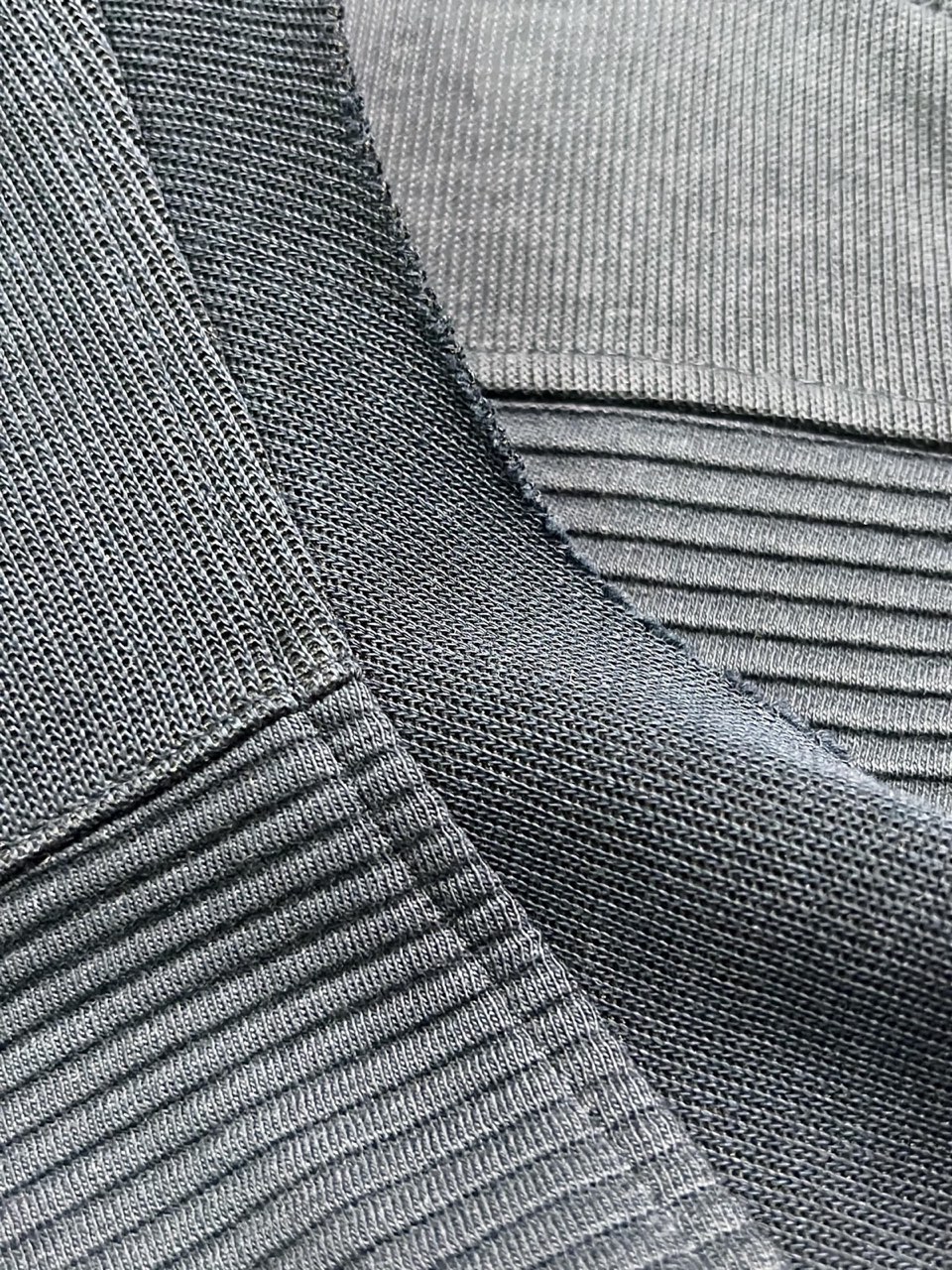 Rippbündchen und Kragennaht an einem dunklen Strickteil